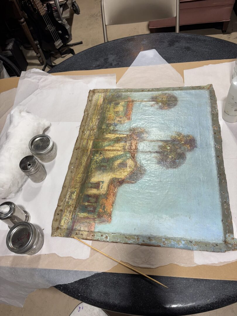 Old painting being restored on worktable