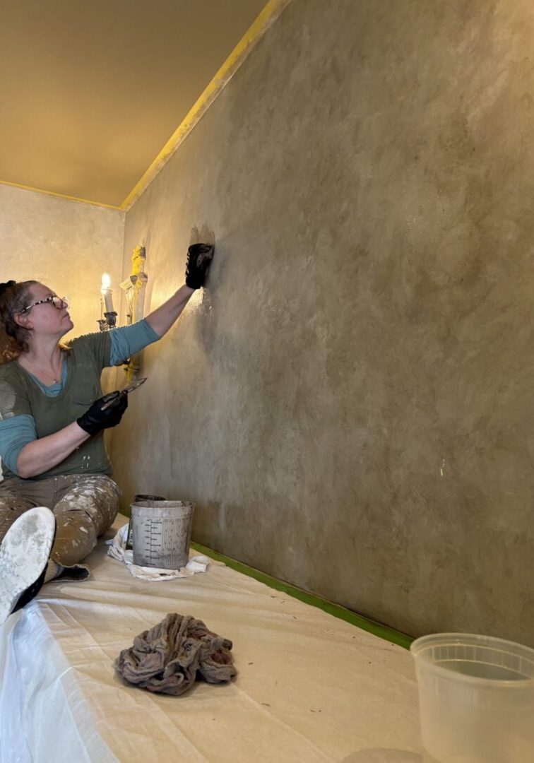 Person plastering wall with trowel